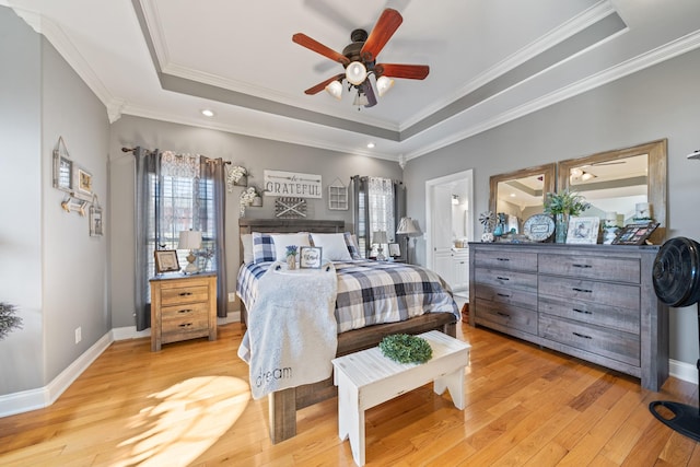 bedroom featuring ceiling fan, light hardwood / wood-style floors, ornamental molding, and a tray ceiling