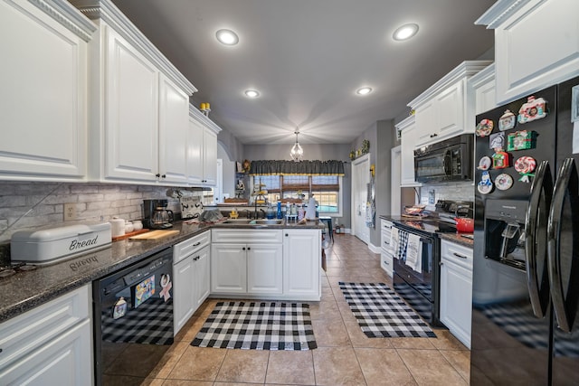 kitchen featuring tasteful backsplash, sink, black appliances, decorative light fixtures, and white cabinetry