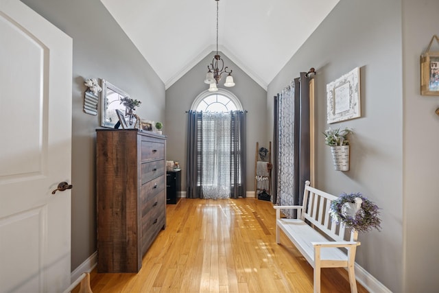 foyer with light wood-type flooring, lofted ceiling, and a notable chandelier