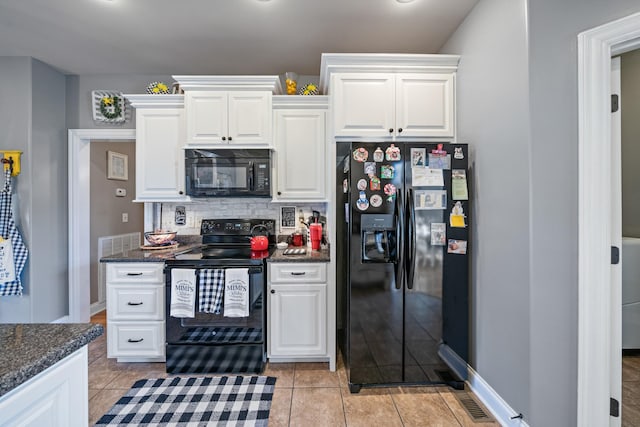 kitchen with white cabinets, light tile patterned floors, dark stone countertops, and black appliances