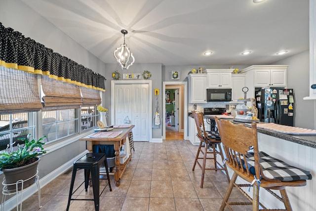 kitchen featuring hanging light fixtures, light tile patterned floors, a chandelier, white cabinets, and black appliances