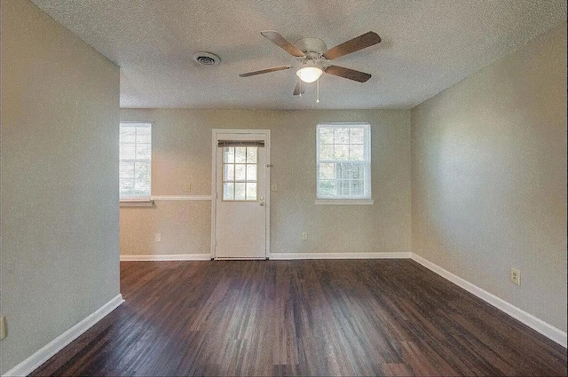 unfurnished room featuring ceiling fan, dark hardwood / wood-style flooring, and a textured ceiling