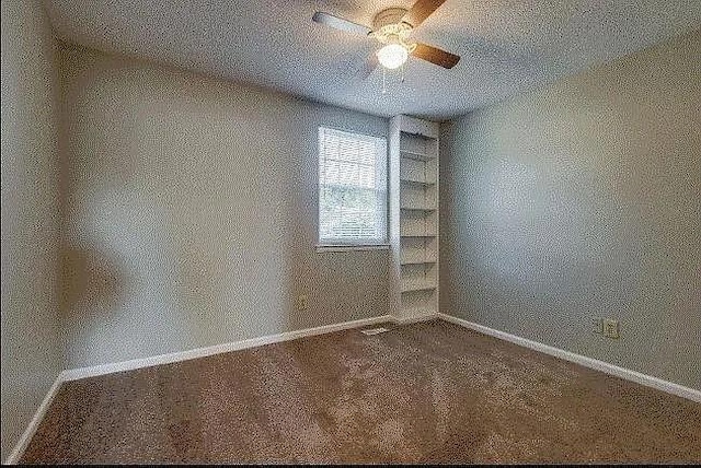 empty room with carpet, ceiling fan, and a textured ceiling