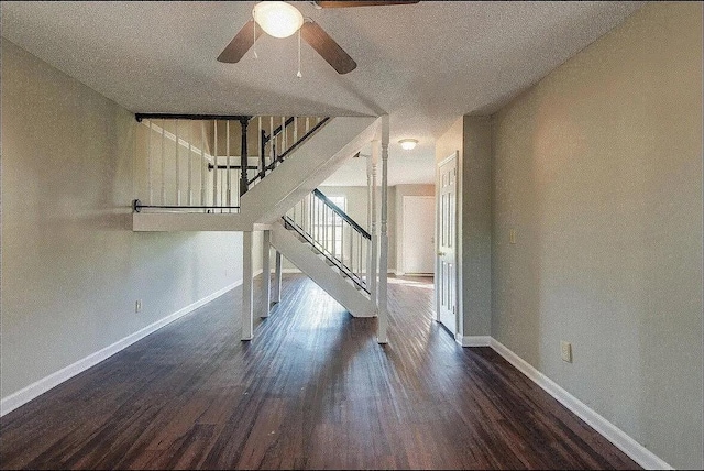 unfurnished living room featuring a textured ceiling, ceiling fan, and dark wood-type flooring