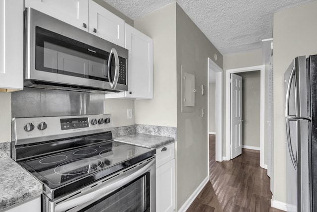 kitchen featuring dark wood-type flooring, a textured ceiling, appliances with stainless steel finishes, white cabinets, and light countertops