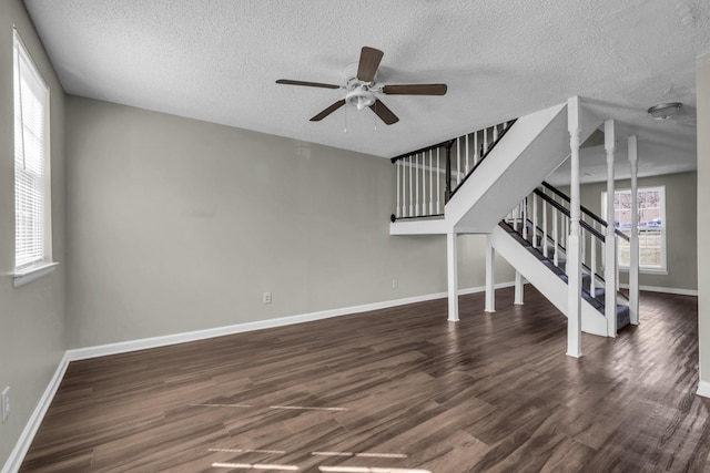 unfurnished living room with a ceiling fan, stairway, wood finished floors, and baseboards