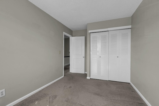 unfurnished bedroom featuring carpet flooring, baseboards, and a closet