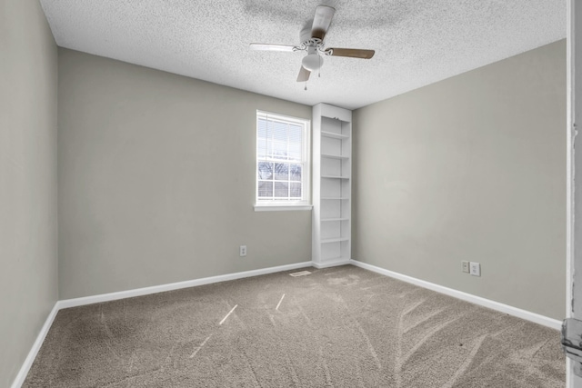 empty room with a textured ceiling, baseboards, carpet, and a ceiling fan