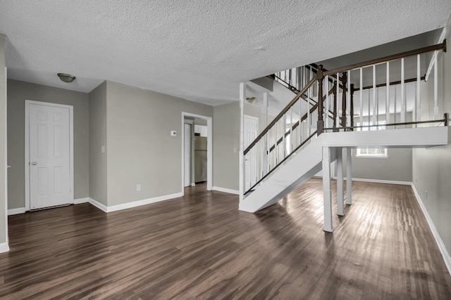 unfurnished living room featuring stairs, dark wood-style floors, baseboards, and a textured ceiling