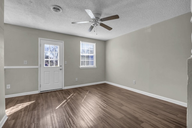 entryway featuring visible vents, dark wood-type flooring, a textured ceiling, baseboards, and ceiling fan