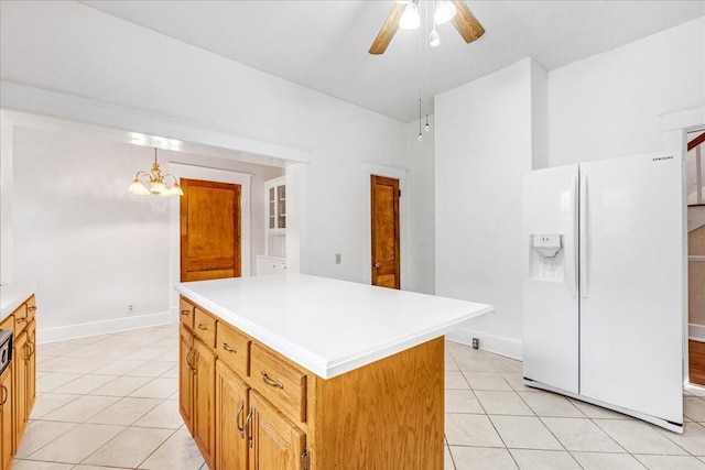 kitchen featuring a center island, white refrigerator with ice dispenser, hanging light fixtures, and light tile patterned floors