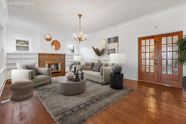 living room featuring dark hardwood / wood-style flooring, french doors, a textured ceiling, and an inviting chandelier