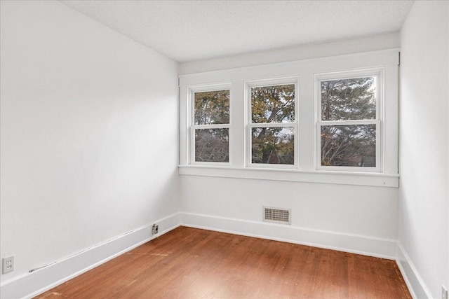 spare room with hardwood / wood-style floors and a textured ceiling