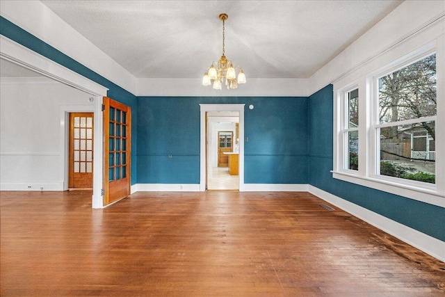 unfurnished dining area with a chandelier and hardwood / wood-style flooring