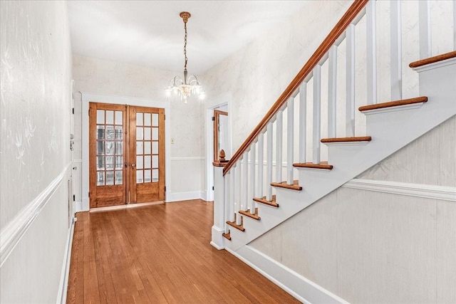 entrance foyer featuring a chandelier, french doors, and hardwood / wood-style floors