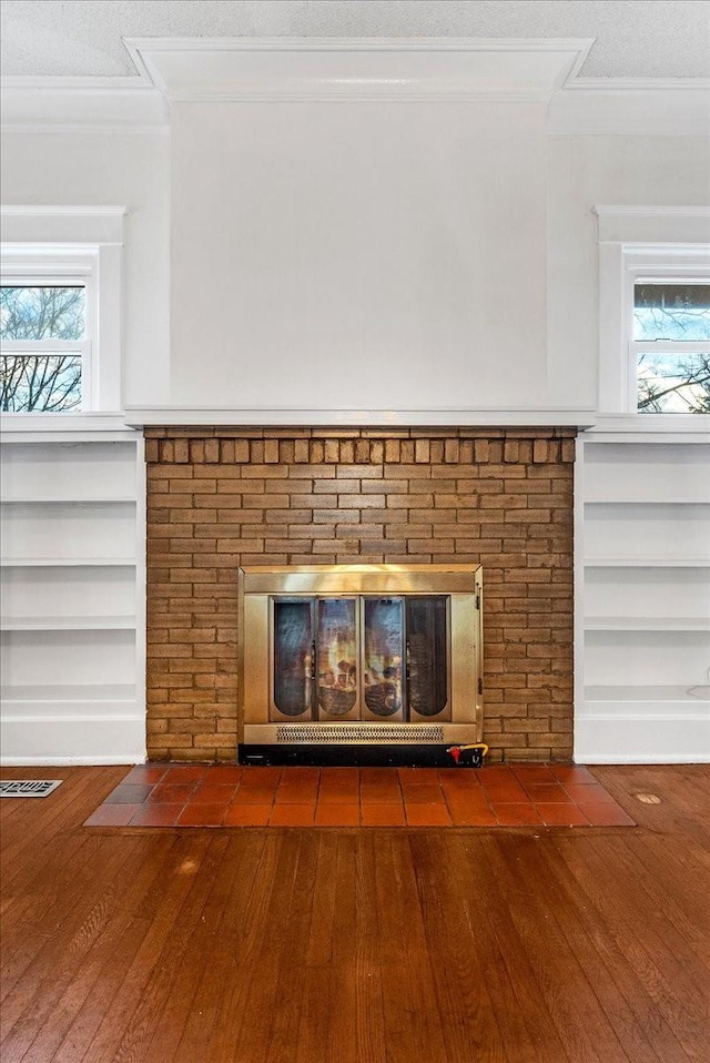 interior details with a fireplace, a textured ceiling, hardwood / wood-style flooring, and built in features