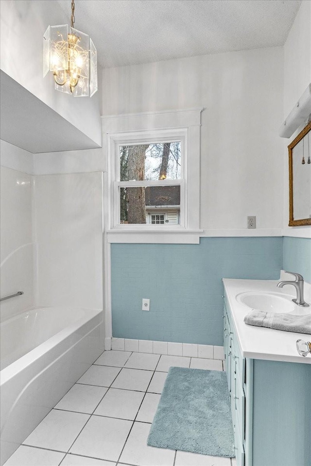 bathroom featuring tile patterned flooring, vanity, a textured ceiling, and an inviting chandelier