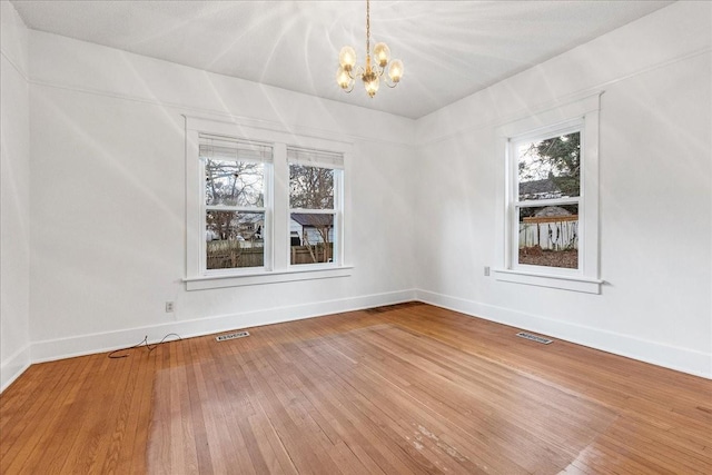 unfurnished dining area with hardwood / wood-style floors and a notable chandelier