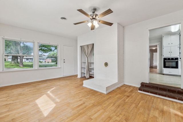 unfurnished living room with ceiling fan and light wood-type flooring