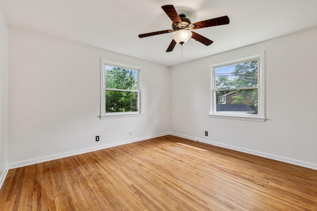 unfurnished room featuring plenty of natural light, ceiling fan, and light wood-type flooring