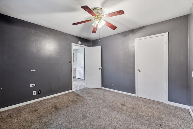 spare room with ceiling fan and light colored carpet