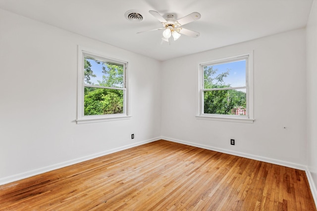 empty room featuring light wood-type flooring, ceiling fan, and a healthy amount of sunlight