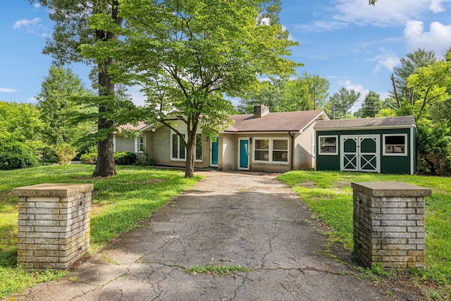 single story home featuring a shed and a front yard