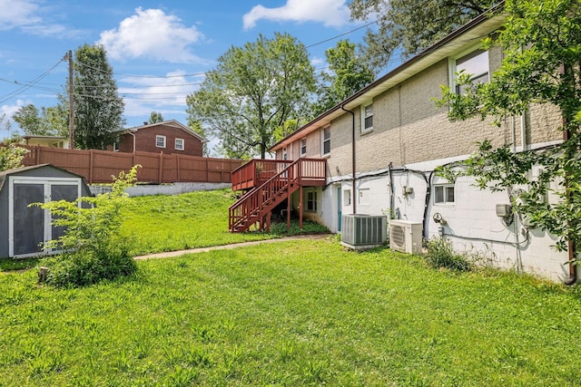 view of yard featuring central AC unit, a storage shed, and a deck