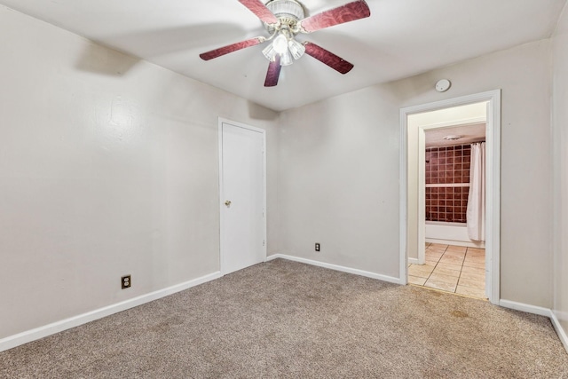 carpeted spare room featuring ceiling fan