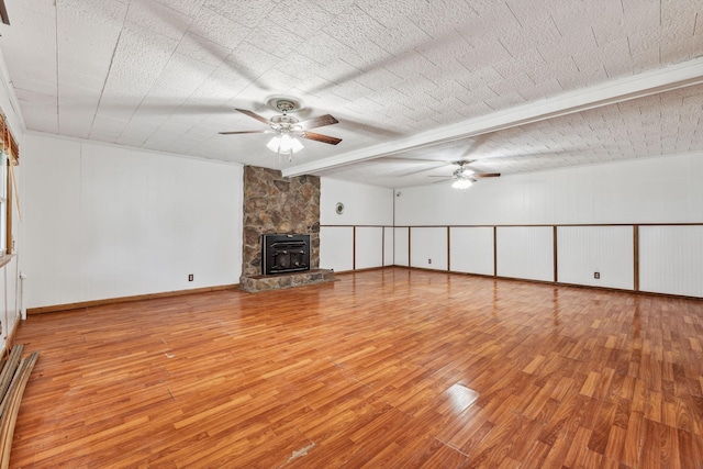 unfurnished living room featuring beamed ceiling, ceiling fan, and light wood-type flooring