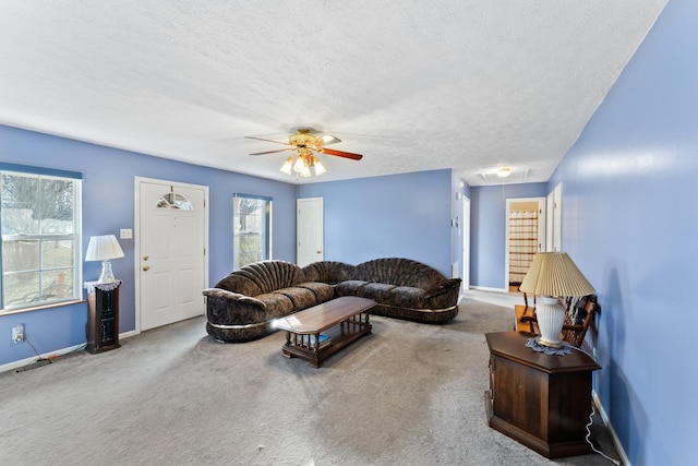 carpeted living room featuring ceiling fan and a textured ceiling