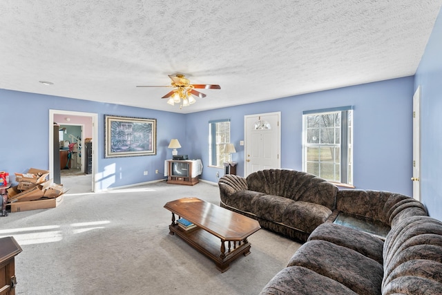 living room with carpet flooring, ceiling fan, and a textured ceiling