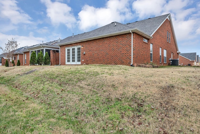 rear view of house with french doors, a lawn, and central air condition unit