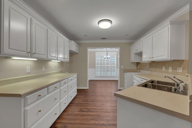 kitchen with white cabinetry, sink, dark hardwood / wood-style flooring, crown molding, and a chandelier