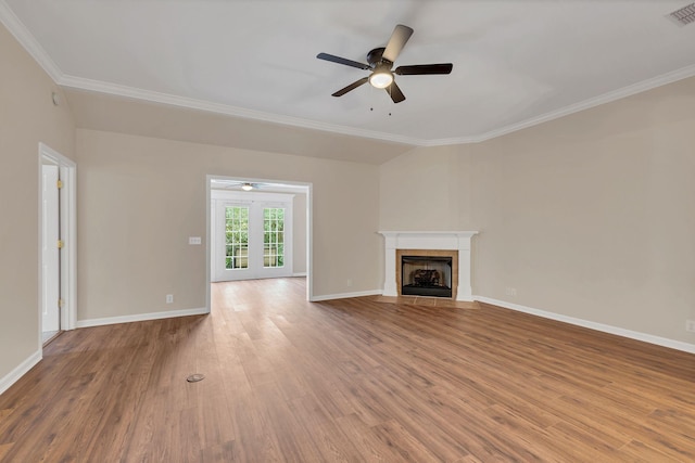 unfurnished living room featuring french doors, ceiling fan, crown molding, hardwood / wood-style flooring, and a fireplace