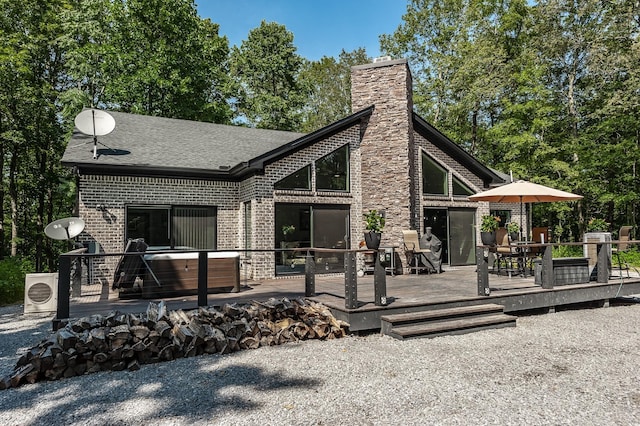 back of property featuring a deck, a hot tub, and ac unit