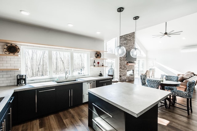 kitchen featuring a fireplace, a center island, tasteful backsplash, and decorative light fixtures