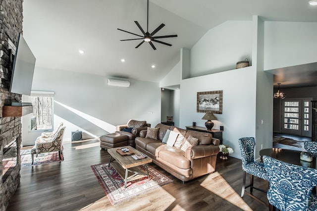 living room featuring a fireplace, a wall mounted air conditioner, high vaulted ceiling, dark hardwood / wood-style flooring, and ceiling fan with notable chandelier