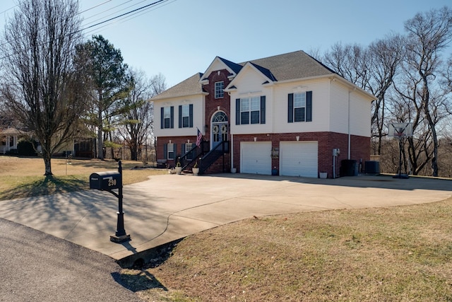 raised ranch featuring central AC, a garage, and a front lawn