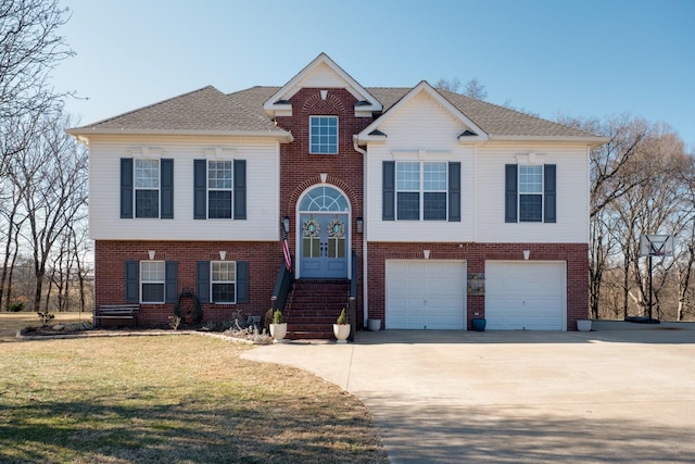 raised ranch featuring a garage and a front yard