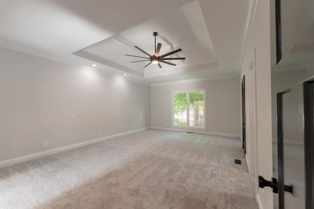 unfurnished room with light colored carpet, a raised ceiling, ceiling fan, and ornamental molding