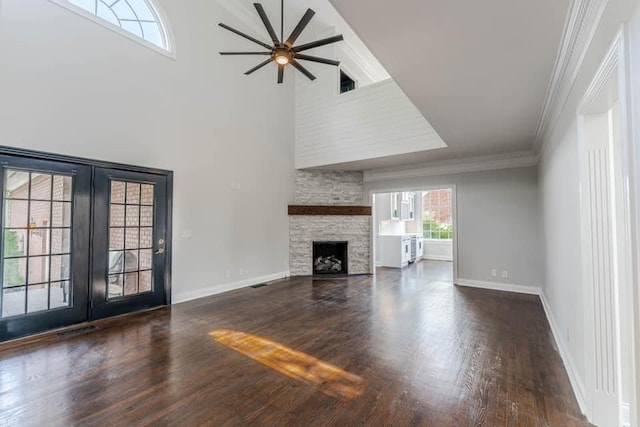 unfurnished living room with a fireplace, dark hardwood / wood-style flooring, crown molding, and a high ceiling