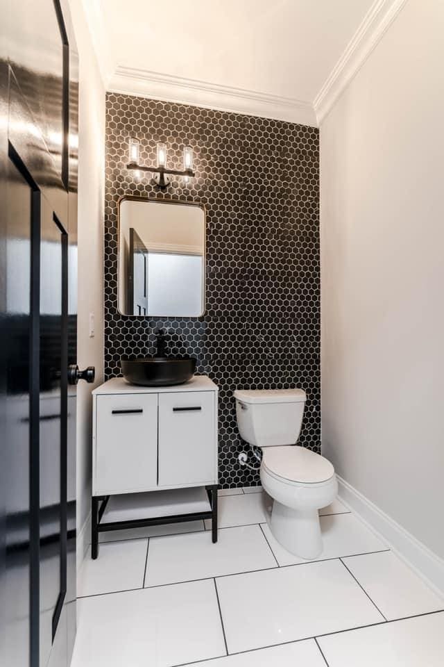 bathroom featuring vanity, tile patterned floors, decorative backsplash, ornamental molding, and tile walls