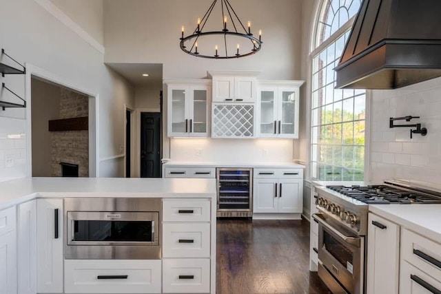 kitchen featuring backsplash, white cabinetry, beverage cooler, and stainless steel appliances