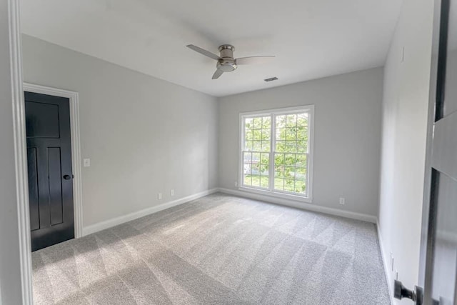 carpeted spare room featuring ceiling fan