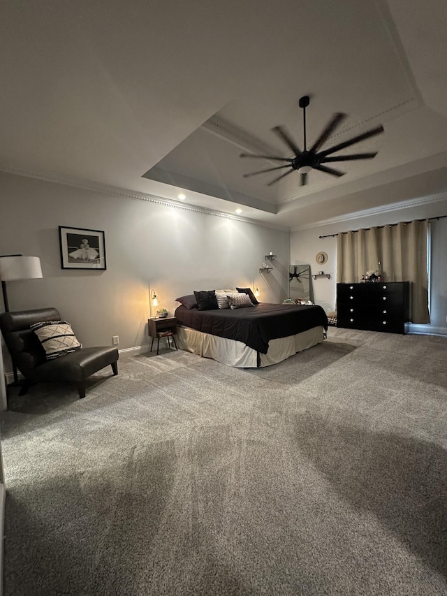 carpeted bedroom featuring a raised ceiling and ceiling fan