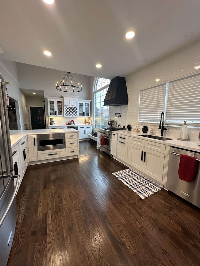 kitchen featuring custom range hood, stainless steel appliances, white cabinetry, and sink