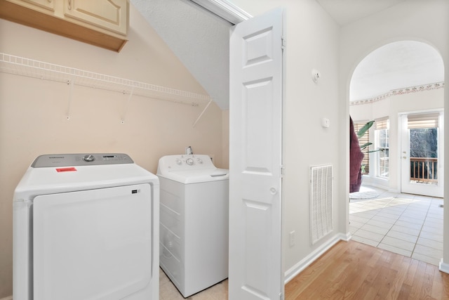 laundry area featuring washer and clothes dryer and light hardwood / wood-style floors