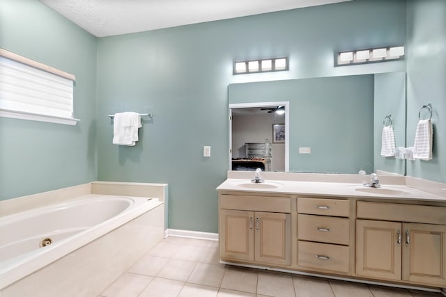 bathroom featuring tile patterned flooring, a bath, vanity, and a textured ceiling