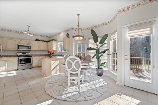 kitchen featuring sink, stainless steel appliances, light stone counters, pendant lighting, and light tile patterned flooring